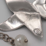 Carica l'immagine nel visualizzatore di Gallery, Dettaglio della superficie stropicciata e del logo della stella della Collana Cielo CACAO Jewels.
