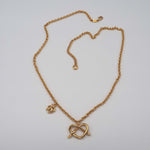 Carica l'immagine nel visualizzatore di Gallery, Collana Promessa CACAO Jewels in ottone placcato in oro 18 carati con pendente a cuore realizzato da un nodo.
