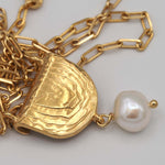 Carica l'immagine nel visualizzatore di Gallery, Dettaglio del pendente inciso e della perla barocca della Collana Impronta CACAO Jewels.

