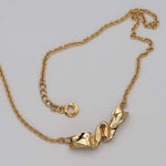 Carica l'immagine nel visualizzatore di Gallery, Dettaglio della superficie modellata della Collana Nastro CACAO Jewels in oro.
