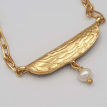 Carica l'immagine nel visualizzatore di Gallery, Dettaglio del pendente inciso e della perla barocca della Collana Riva CACAO Jewels.
